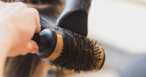 Sử dụng lược tròn và máy sấy tóc để giúp tóc vào nếp